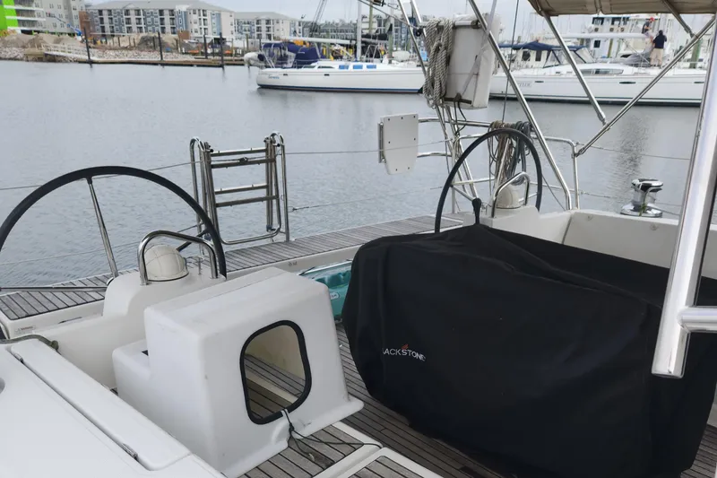 Slide: The Image of 2013 Beneteau Oceanis 48 sailboat cockpit with dual steering wheels in a marina. - 14