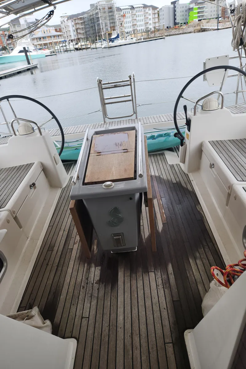 Slide: The Image of 2013 Beneteau Oceanis 48 yacht cockpit with dual steering wheels, docked in a marina. - 15