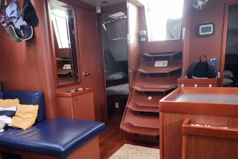 Slide: The Image of Interior of 2013 Beneteau Oceanis 48 sailboat with wooden finish and blue seating. - 17