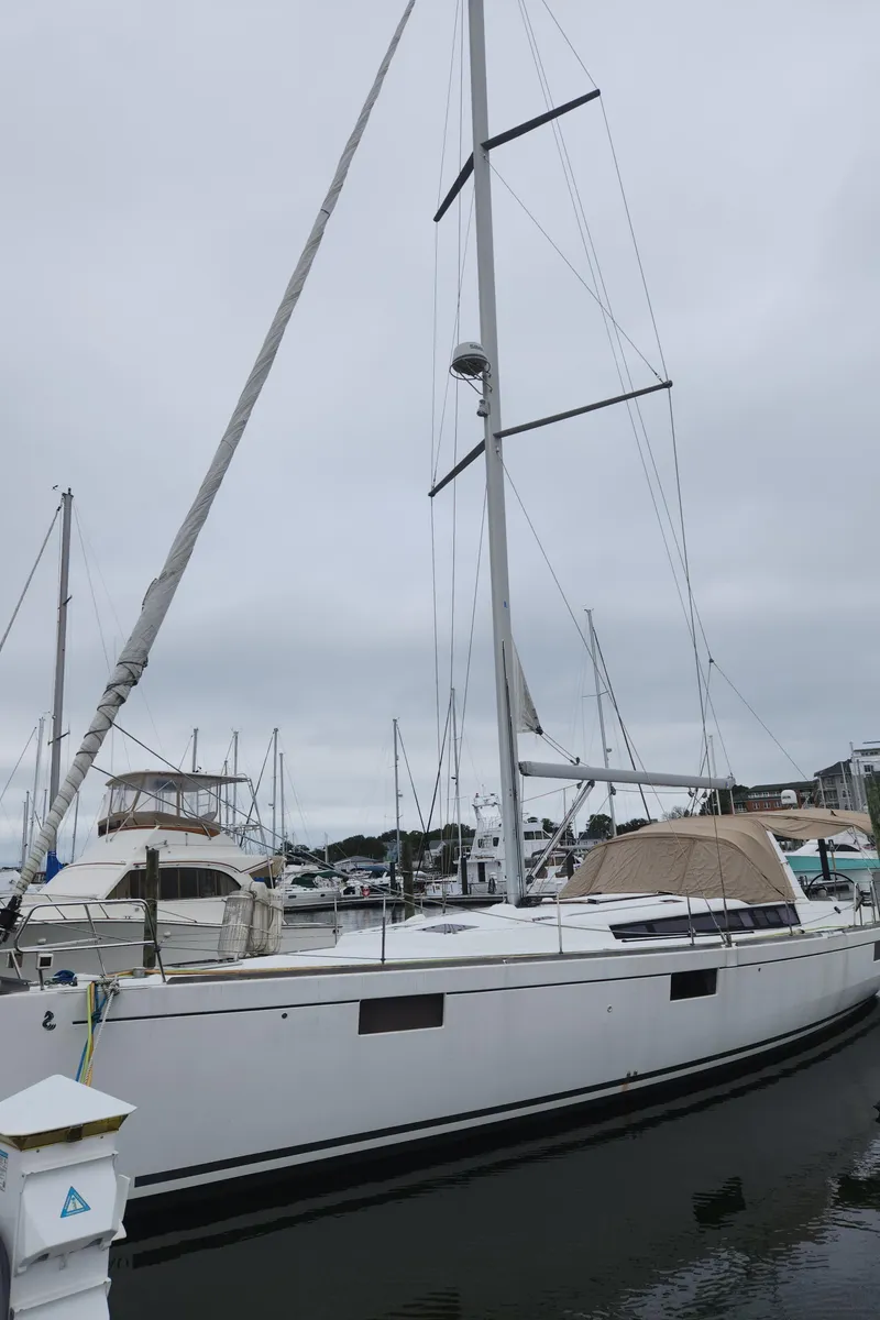 Slide: The Image of 2013 Beneteau Oceanis 48 sailboat docked at marina under cloudy sky. - 8