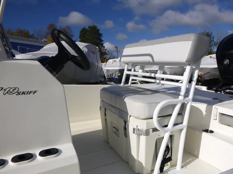 Slide: The Image of 2022 Mako 19CC boat interior with seating and steering wheel under blue sky. - 12