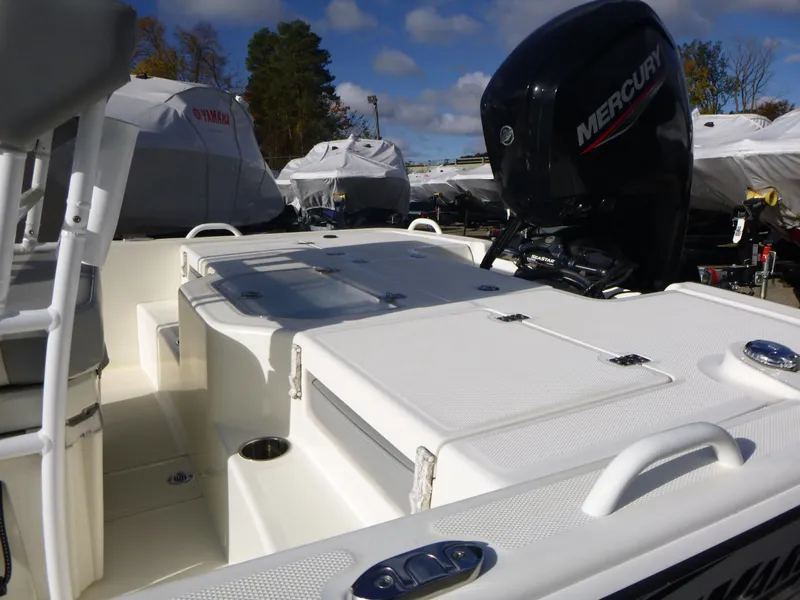 Slide: The Image of 2022 Mako 19CC boat with Mercury engine, docked outdoors under blue sky. - 13