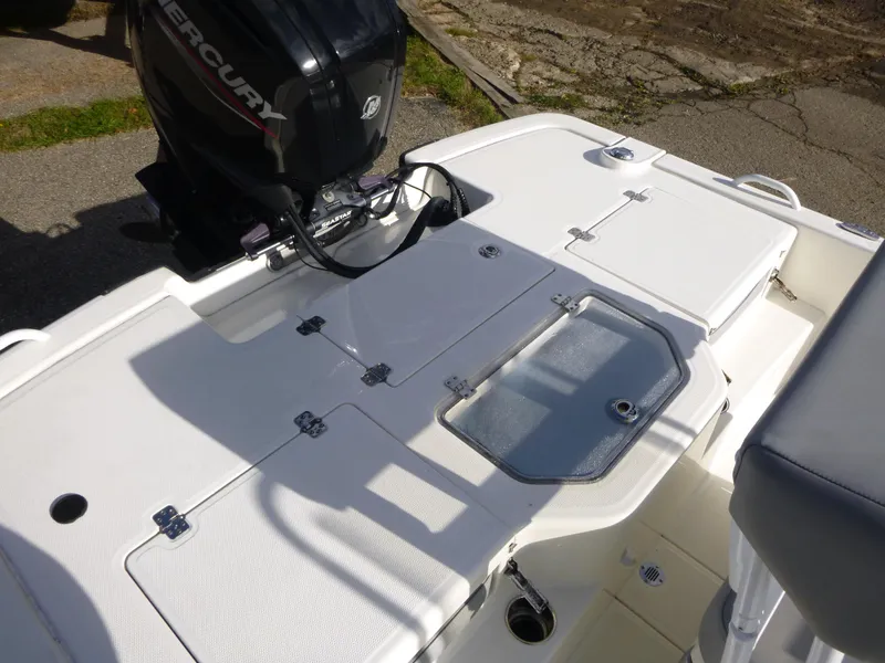 Slide: The Image of 2022 Mako 19CC boat deck with Mercury engine, featuring storage compartments. - 15