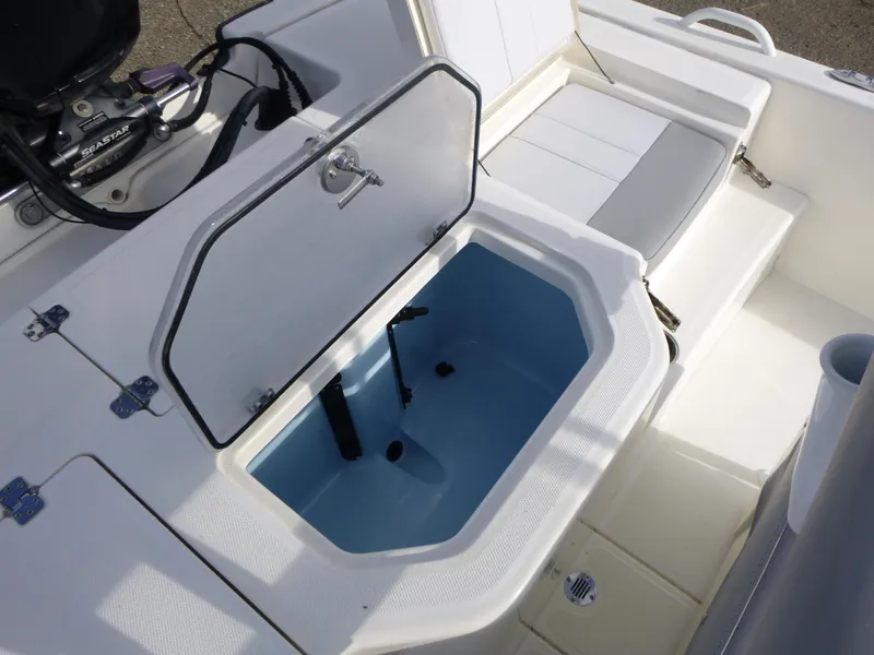 Slide: The Image of 2022 Mako 19CC boat interior with open storage compartment and seating. - 17