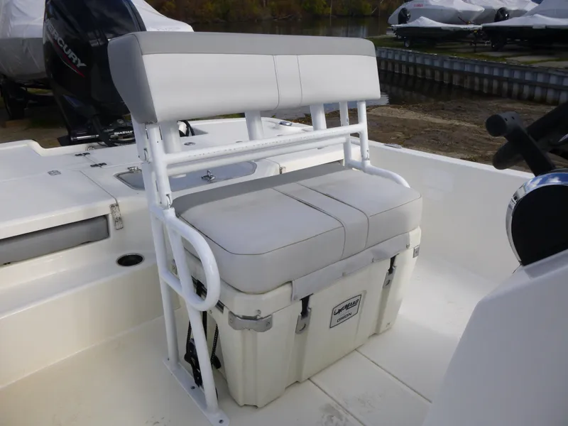 Slide: The Image of 2022 Mako 19CC boat with cushioned seating and storage compartment. - 19