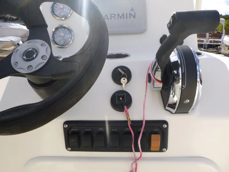 Slide: The Image of 2022 Mako 19CC boat dashboard with steering wheel and controls. - 22