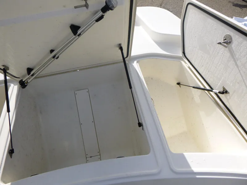 Slide: The Image of 2022 Mako 19CC boat storage compartments open, showcasing spacious interior design. - 30