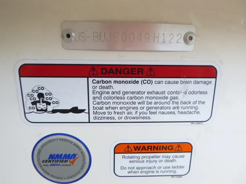 Slide: The Image of Warning labels on 2022 Mako 19CC boat highlighting carbon monoxide and propeller hazards. - 33