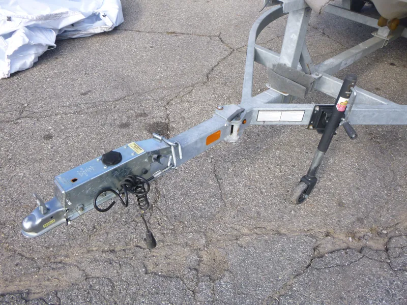 Slide: The Image of Trailer hitch of a 2022 Mako 19CC boat on pavement. - 7