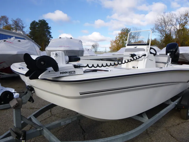 Slide: The Image of 2022 Mako 19CC boat on trailer with Minn Kota motor, parked outdoors. - 8