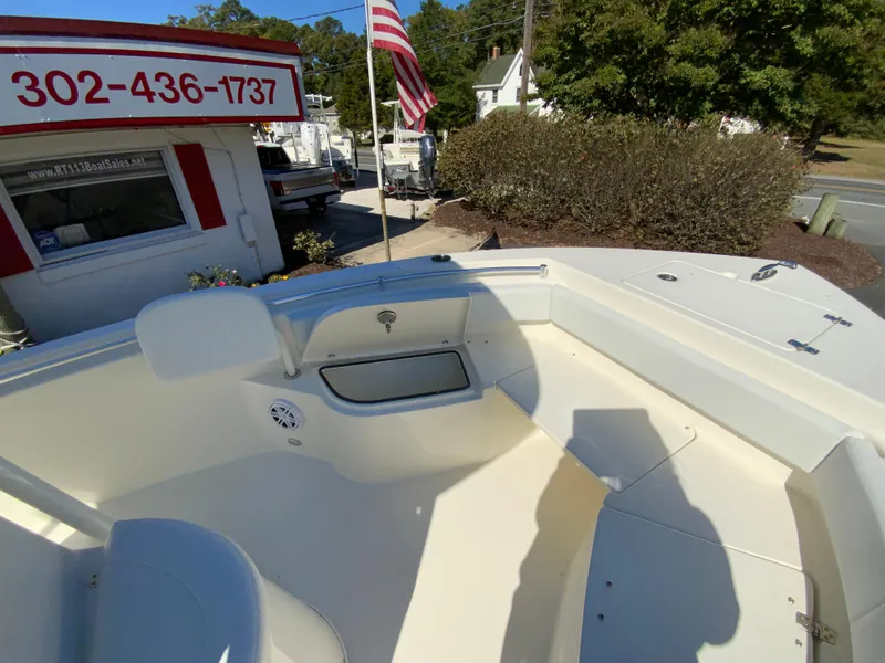 Slide: The Image of 2025 Cobia 220 Center Console boat, outdoor dealership display, American flag in background. - 12