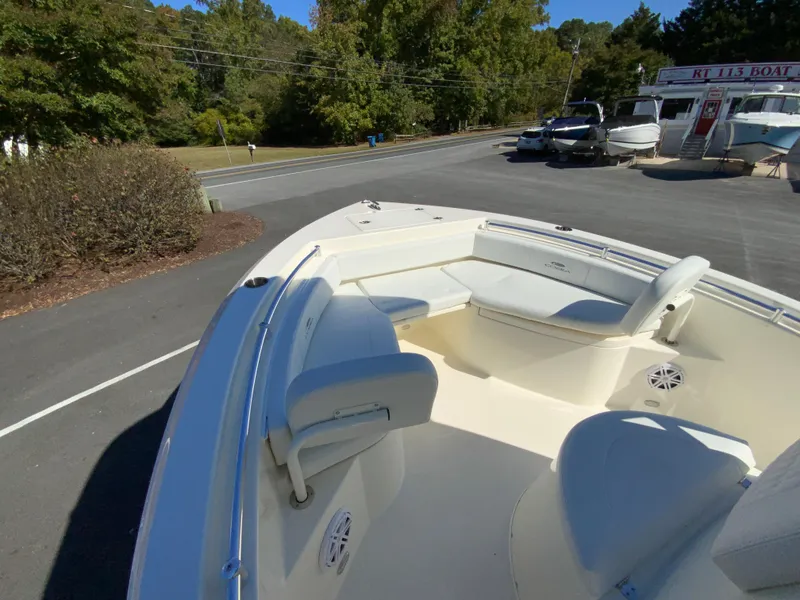 Slide: The Image of 2025 Cobia 220 Center Console boat with spacious seating, parked outdoors. - 14