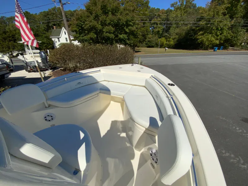 Slide: The Image of 2025 Cobia 220 Center Console boat with seating, parked outdoors. - 15