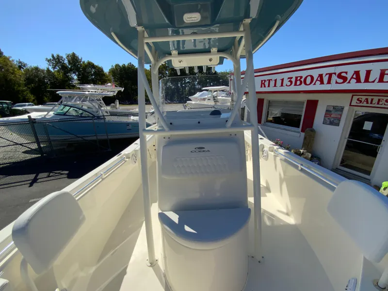 Slide: The Image of 2025 Cobia 220 Center Console boat at dealership, sunny day. - 16