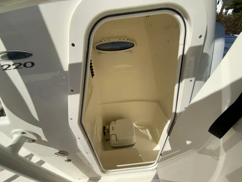 Slide: The Image of 2025 Cobia 220 Center Console boat interior with compact toilet. - 19