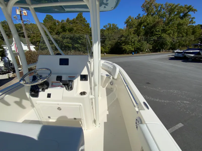 Slide: The Image of 2025 Cobia 220 Center Console boat parked outdoors, showcasing helm and seating area. - 20