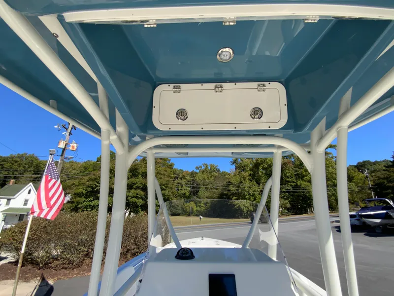 Slide: The Image of 2025 Cobia 220 Center Console boat with T-top and American flag in background. - 22