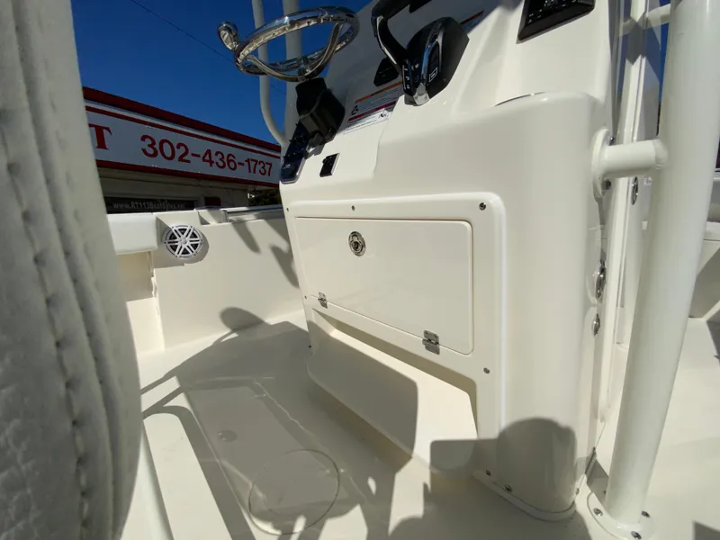 Slide: The Image of 2025 Cobia 220 Center Console boat interior with steering wheel and storage compartment. - 26
