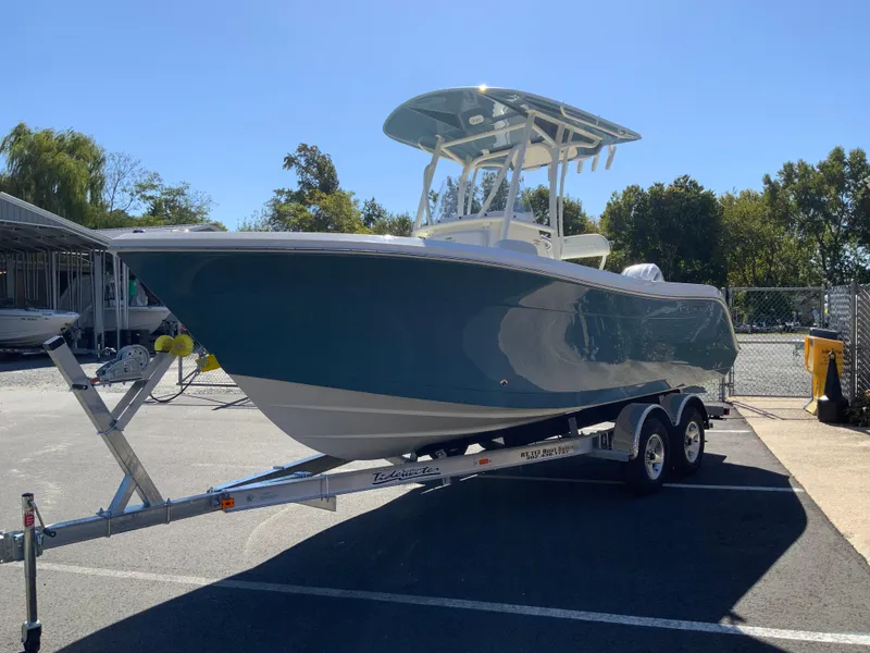 Slide: The Image of 2025 Cobia 220 Center Console boat on trailer in sunny parking lot. - 3