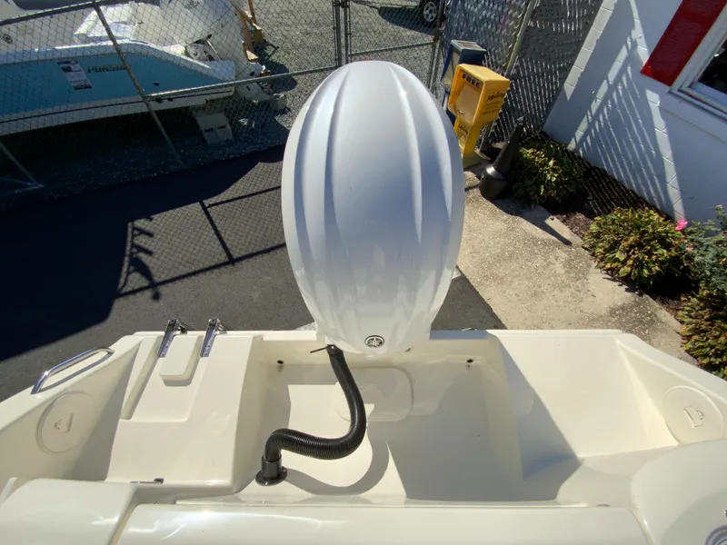 Slide: The Image of 2025 Cobia 220 Center Console boat engine view in a marina setting. - 36