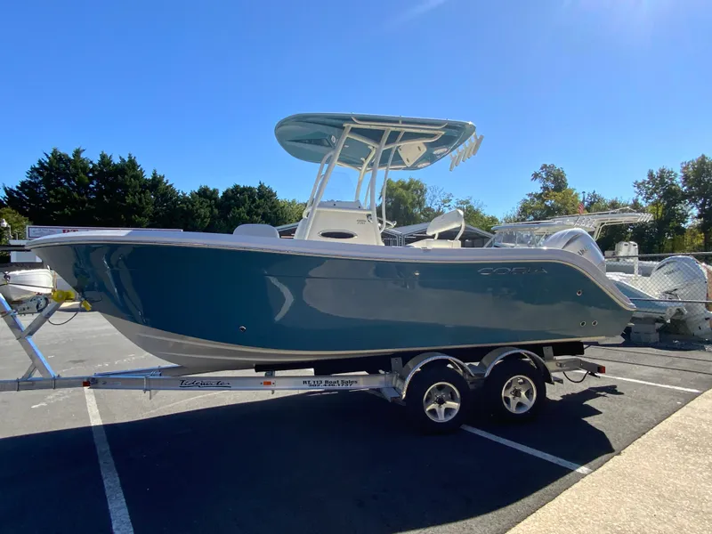 Slide: The Image of 2025 Cobia 220 Center Console boat on trailer, parked outdoors. - 4