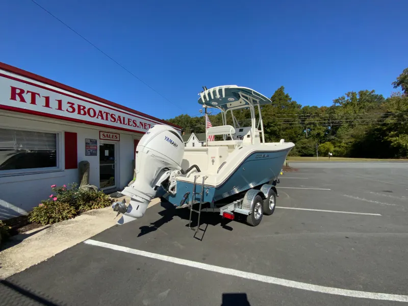 Slide: The Image of 2025 Cobia 220 Center Console boat on trailer at dealership parking lot. - 6
