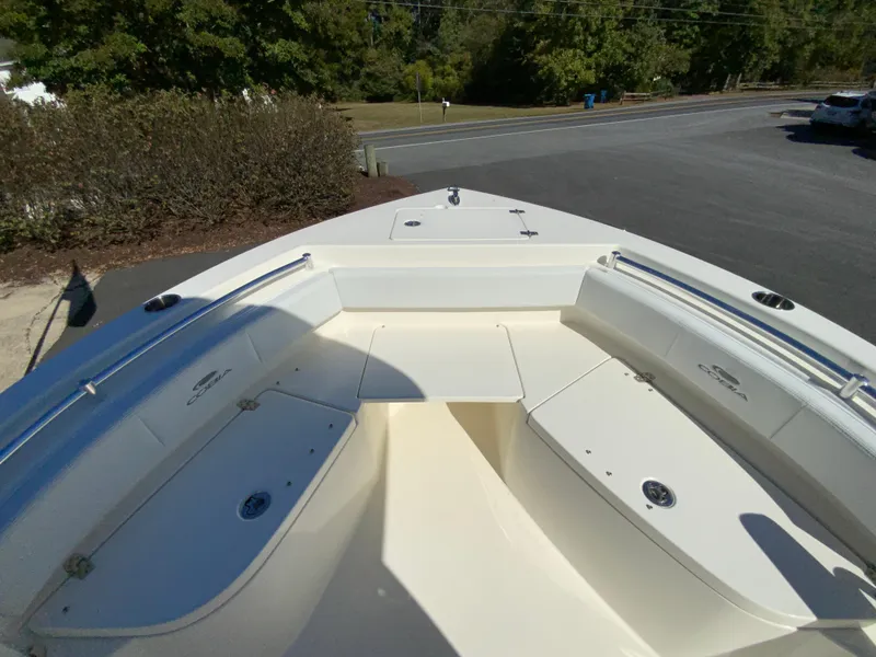 Slide: The Image of 2025 Cobia 220 Center Console boat, spacious deck, parked outdoors. - 9