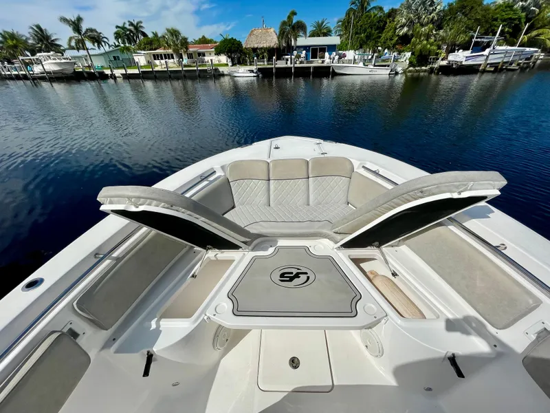 Slide: The Image of 2019 Sea Fox 288 Commander boat with open seating, docked in a scenic waterfront area. - 2