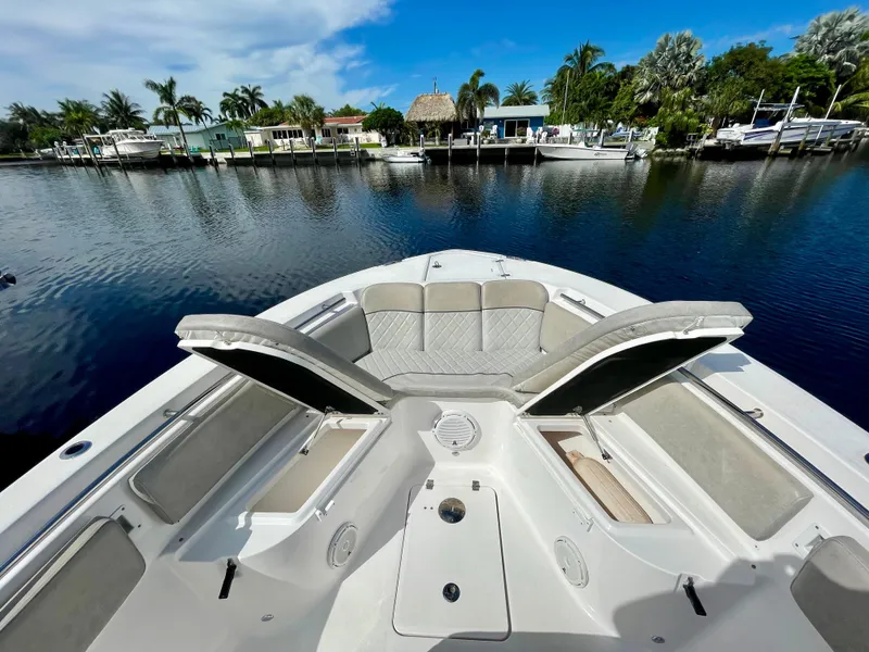Slide: The Image of 2019 Sea Fox 288 Commander boat on a calm waterfront with open storage compartments. - 3