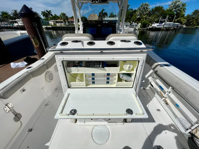 Slide: The Image of 2019 Sea Fox 288 Commander boat with open storage compartment, docked by a scenic waterfront. - 33
