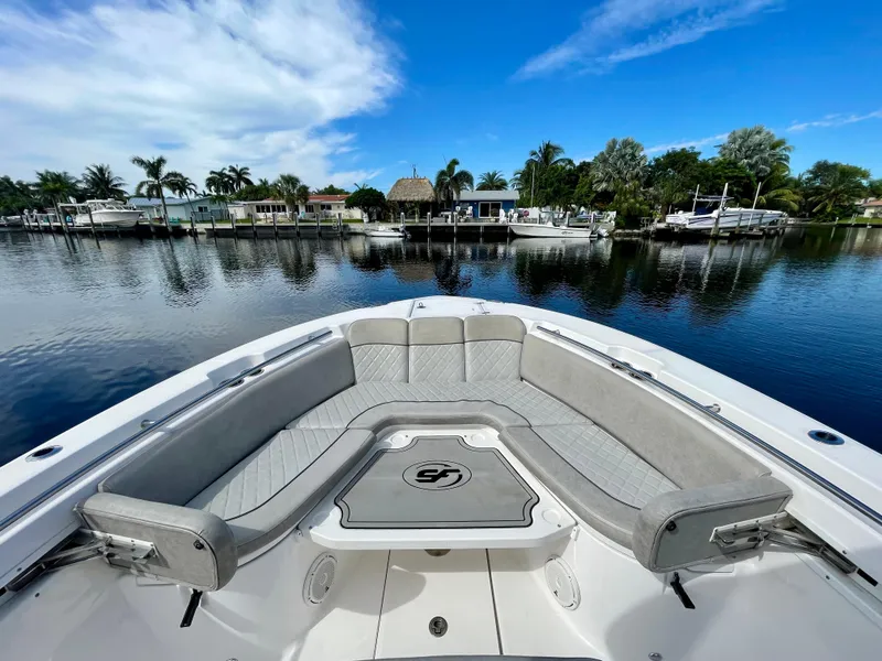 Slide: The Image of 2019 Sea Fox 288 Commander boat with spacious seating, docked by a scenic waterfront. - 4