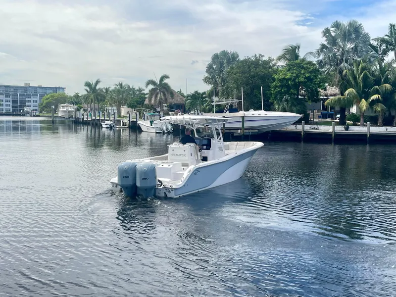 Slide: The Image of 2019 Sea Fox 288 Commander boat cruising on a calm waterway with palm trees in the background. - 42