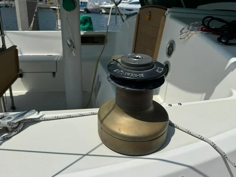 Slide: The Image of 1982 Pearson Ketch sailboat deck with winch and ropes in marina setting. - 11