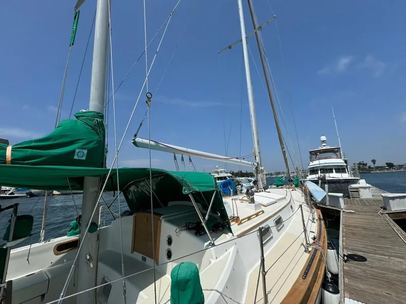 Slide: The Image of 1982 Pearson Ketch sailboat docked at marina under clear blue sky. - 15