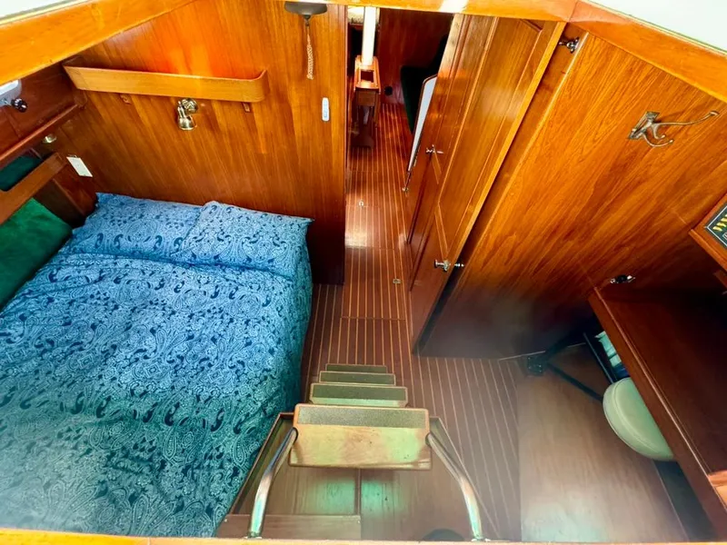 Slide: The Image of Interior of 1982 Pearson Ketch sailboat with wooden finish and cozy sleeping area. - 19