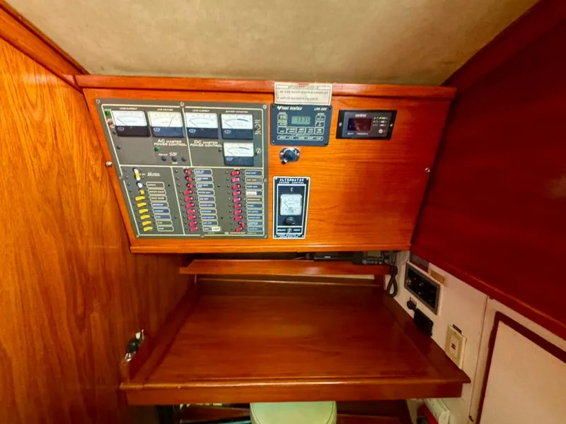 Slide: The Image of 1982 Pearson Ketch electrical panel with wooden cabinetry and control switches. - 20