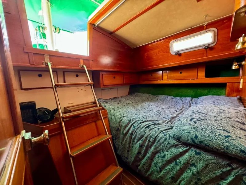 Slide: The Image of Cozy cabin interior of 1982 Pearson Ketch sailboat with wooden finish and bedding. - 24