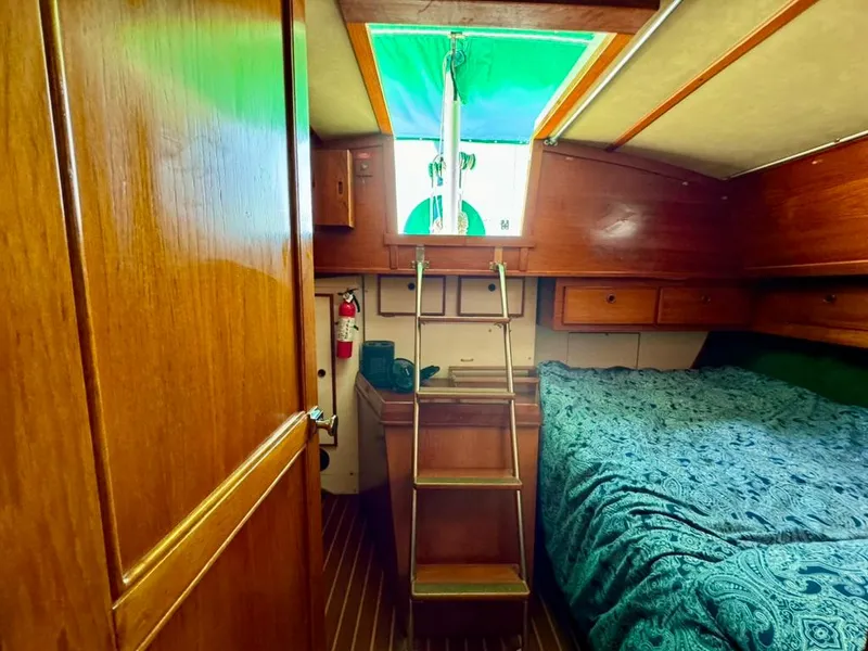 Slide: The Image of Cozy cabin interior of 1982 Pearson Ketch sailboat with wooden finish and bedding. - 25