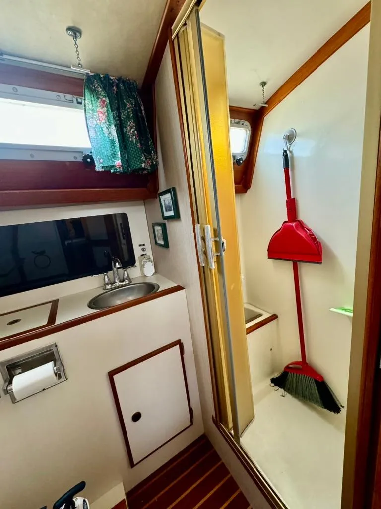 Slide: The Image of 1982 Pearson Ketch bathroom with sink, shower, and cleaning tools. - 26