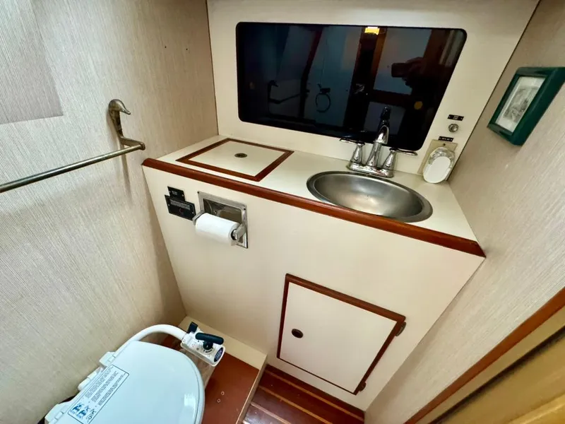 Slide: The Image of 1982 Pearson Ketch yacht bathroom with sink, toilet, and storage cabinet. - 29