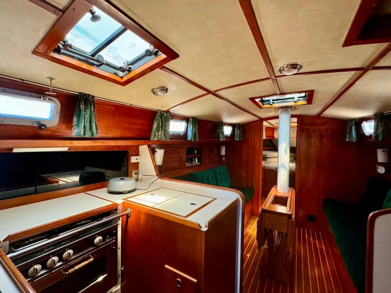 Slide: The Image of Interior of 1982 Pearson Ketch sailboat with wood finish and compact kitchen. - 30