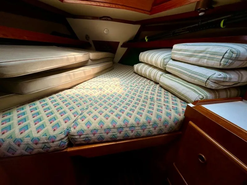Slide: The Image of 1982 Pearson Ketch cabin with patterned cushions and wooden interior. - 33