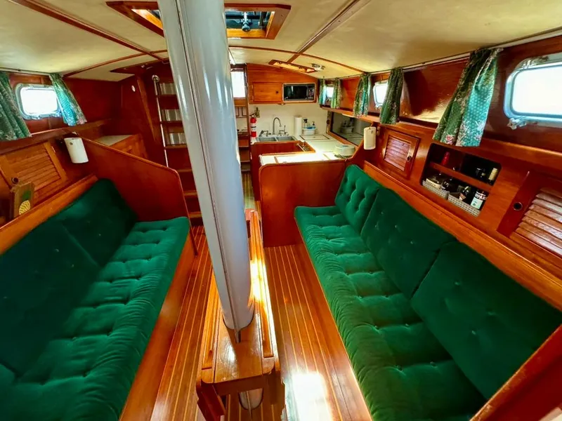 Slide: The Image of Interior of 1982 Pearson Ketch sailboat with green upholstery and wooden finishes. - 34