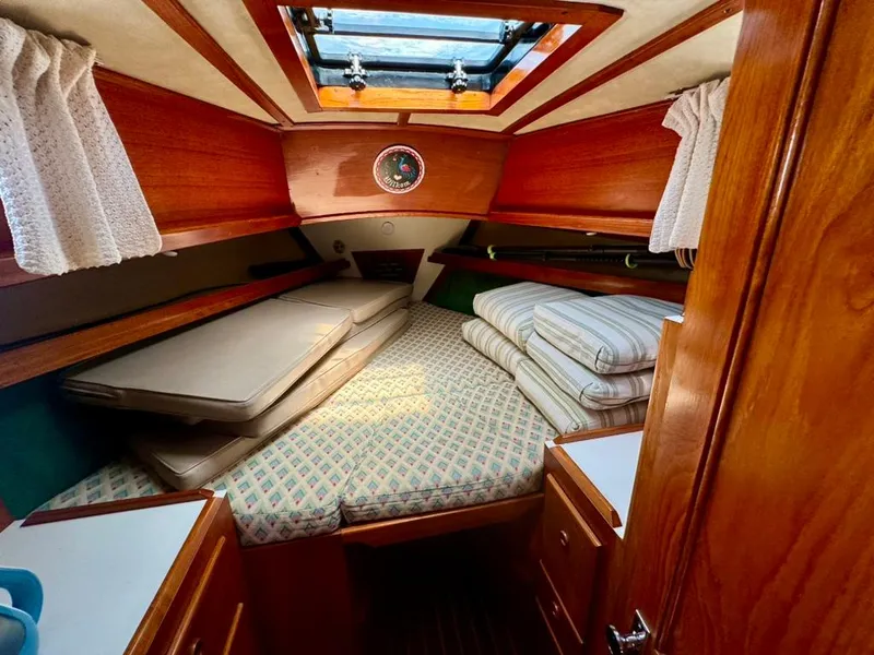 Slide: The Image of Cozy cabin interior of 1982 Pearson Ketch sailboat with wooden finish and bedding. - 39