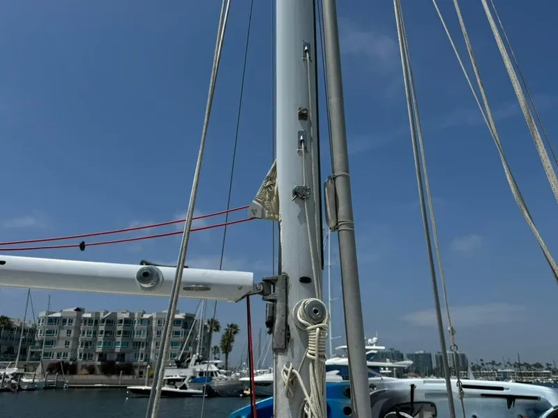 Slide: The Image of Pearson Ketch 1982 sailboat mast and rigging in marina, clear sky background. - 4