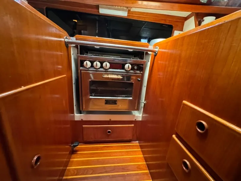 Slide: The Image of 1982 Pearson Ketch yacht kitchen with wooden cabinetry and stainless steel oven. - 44