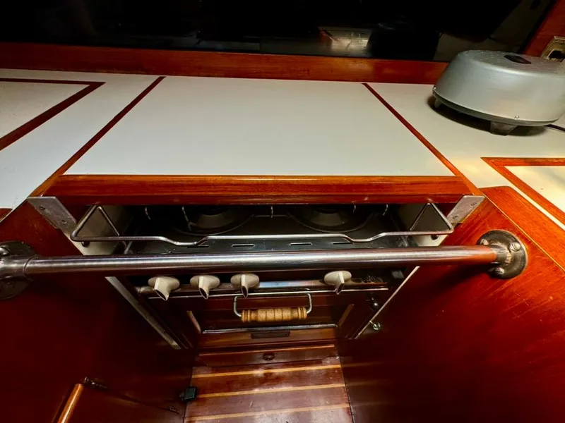 Slide: The Image of 1982 Pearson Ketch interior kitchen with stove and wooden cabinetry. - 45