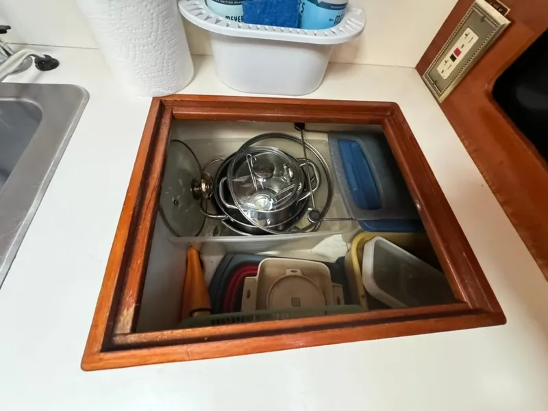 Slide: The Image of Storage compartment with kitchenware on 1982 Pearson Ketch sailboat. - 47