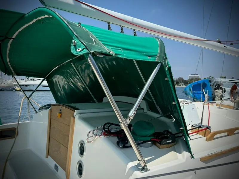 Slide: The Image of 1982 Pearson Ketch sailboat with green canopy in marina. - 8