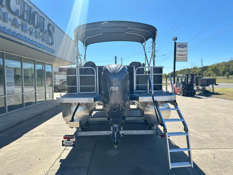 Slide: The Image of 2025 Bennington 22 SXS APG pontoon boat with Yamaha 150 engine, parked outside dealership. - 3